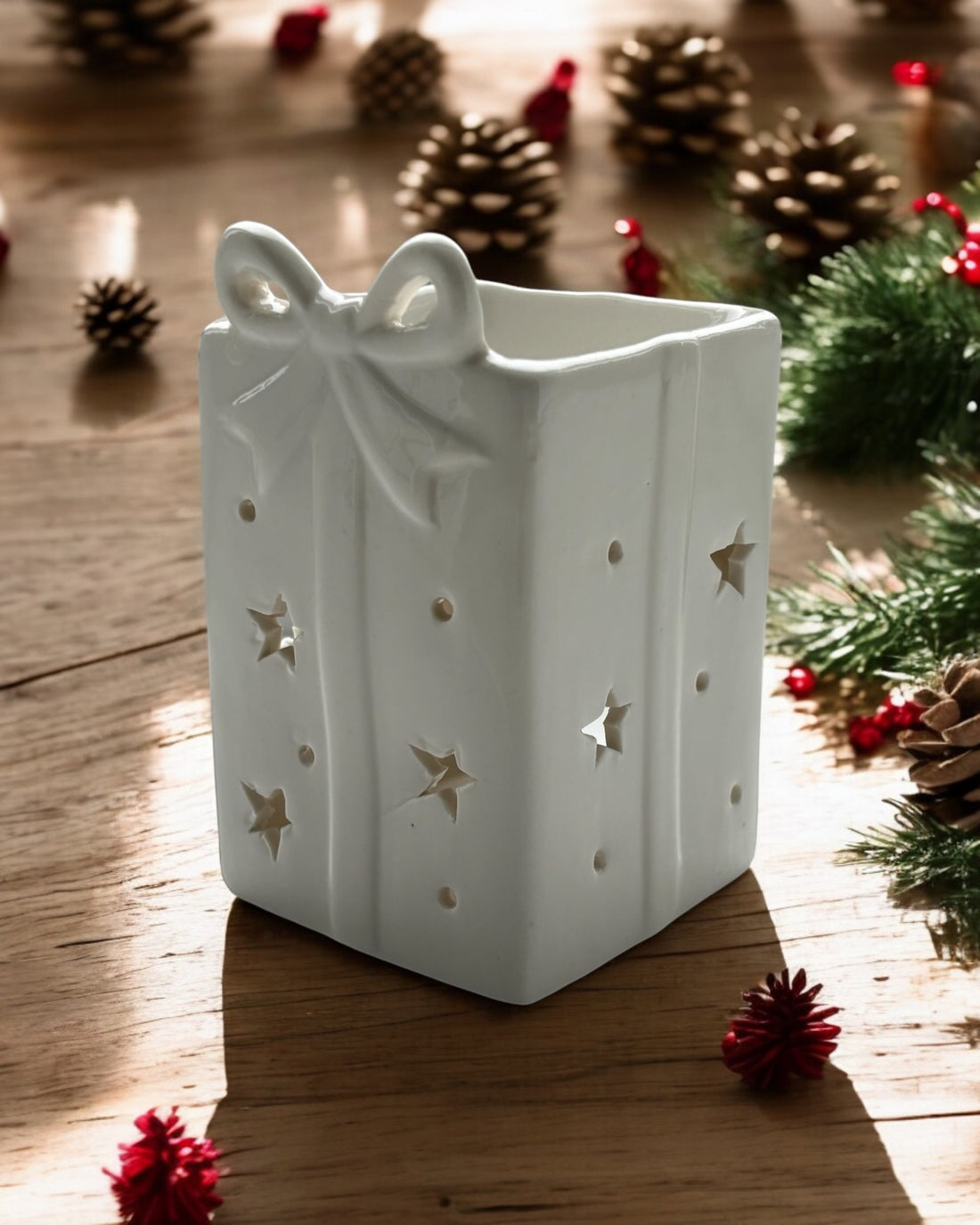 Ceramic wax melt burner shaped like a Christmas present box, ideal for spreading holiday home fragrance.